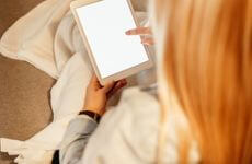 blonde lady reading blog on tablet